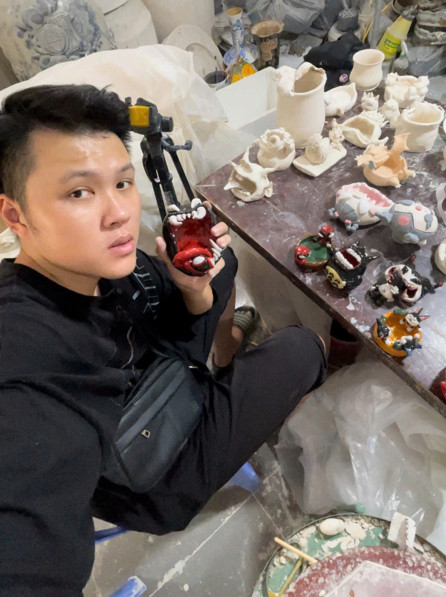 Tuấn Long chụp cùng các sản phẩm gốm quái dị do anh bạn làm. ẢNH: NVCC Tuấn Long chụp cùng các sản phẩm gốm quái dị do anh bạn làm. ẢNH: NVCC