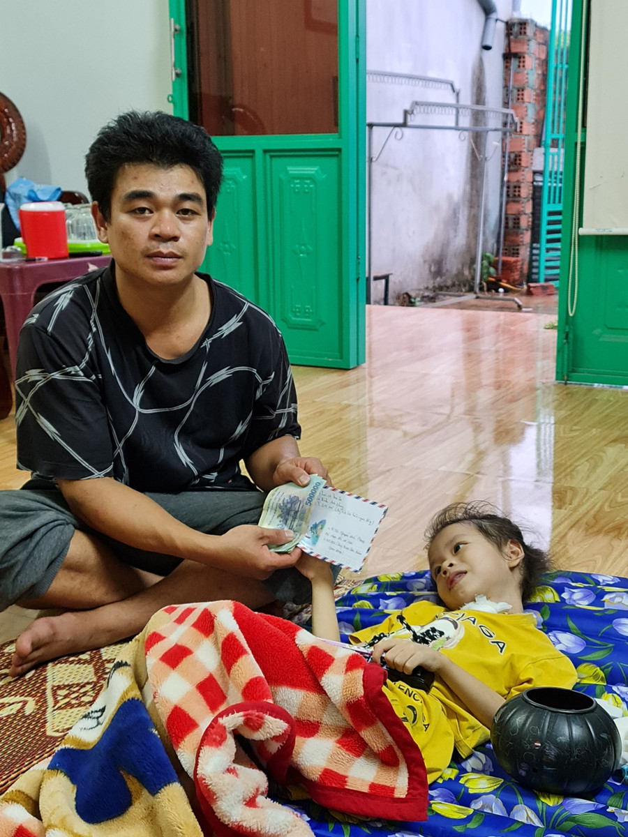 Anh Nguyễn Đức Phong nhận tiền do Báo Gia Lai và bạn đọc hỗ trợ. Ảnh: Lệ Hằng