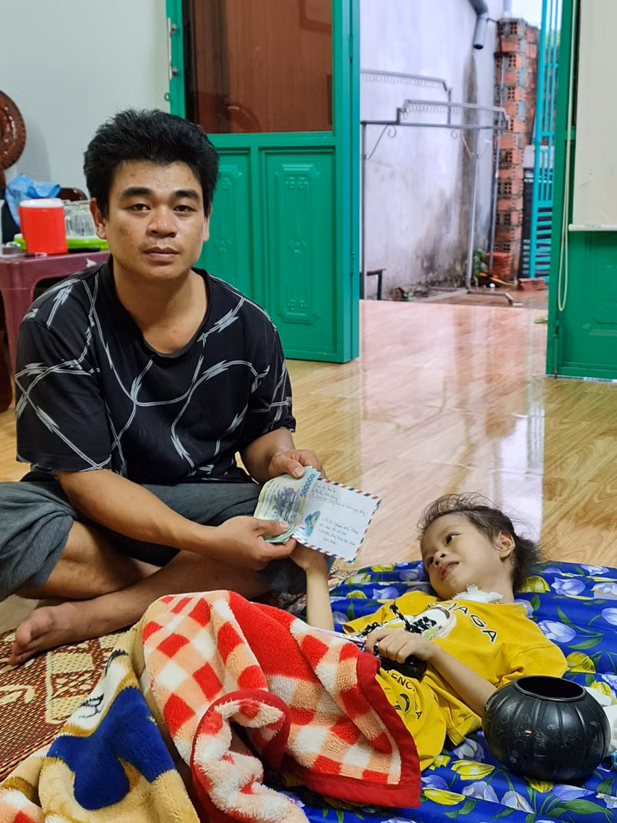 Anh Nguyễn Đức Phong nhận tiền do Báo Gia Lai và bạn đọc hỗ trợ. Ảnh: Lệ Hằng