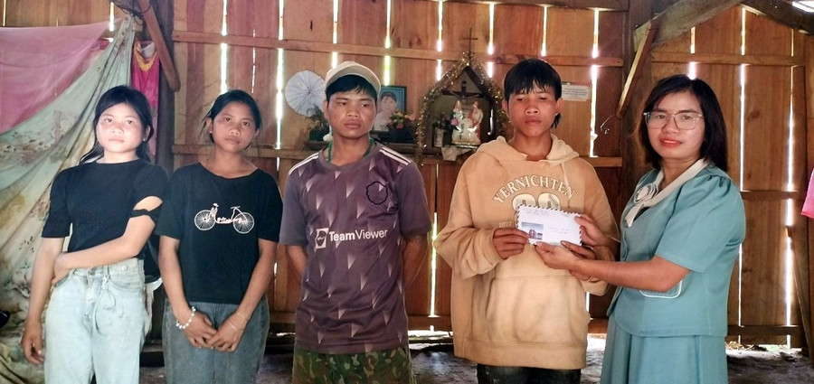 Trao tiền hỗ trợ cho các con ông A Plớp tiếp sức đến trường. Ảnh: PN