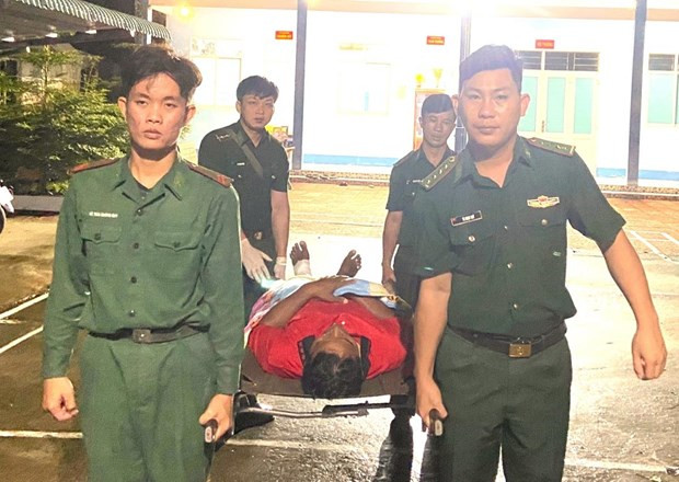 Cán bộ, chiến sỹ Đồn Biên phòng Khánh Hội hỗ trợ đưa thuyền viên bị thương ở chân đi cấp cứu. (Ảnh: Đơn vị cung cấp) Cán bộ, chiến sỹ Đồn Biên phòng Khánh Hội hỗ trợ đưa thuyền viên bị thương ở chân đi cấp cứu. (Ảnh: Đơn vị cung cấp)