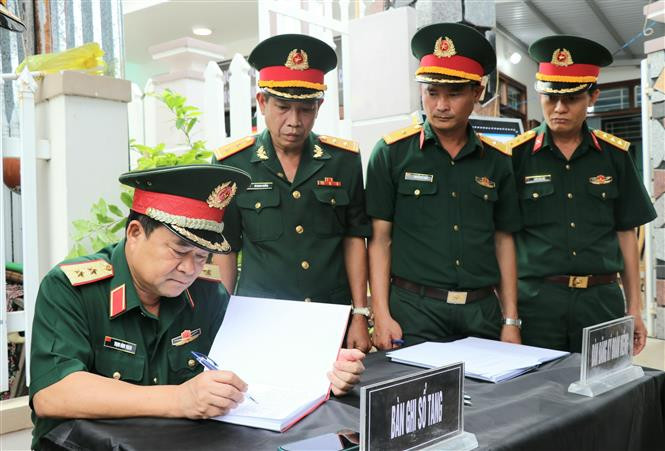 Trung tướng Trịnh Đình Thạch, Bí thư Đảng ủy, Chính ủy Quân Khu 5 ghi sổ tang tại lễ viếng Trung tá Trương Hồng Kỳ. Ảnh: Xuân Triệu - TTXVN