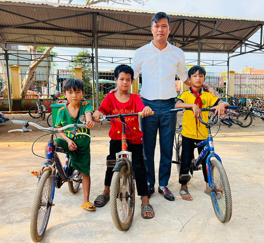 Thầy Trương Thanh Tùng-giáo viên Tổng phụ trách Đội Trường Tiểu học Bùi Thị Xuân và các em học sinh được mượn xe đạp. Ảnh: Minh Nhật