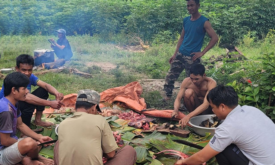 Những người đàn ông phụ trách việc mổ thịt bò để chuẩn bị bữa cơm cộng cảm. Ảnh: M.H