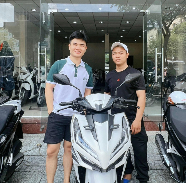 Anh Trần Hữu Mãng (áo đen, bên phải) và chiếc xe Honda Vario thời điểm mới mua. Ảnh: NVCC