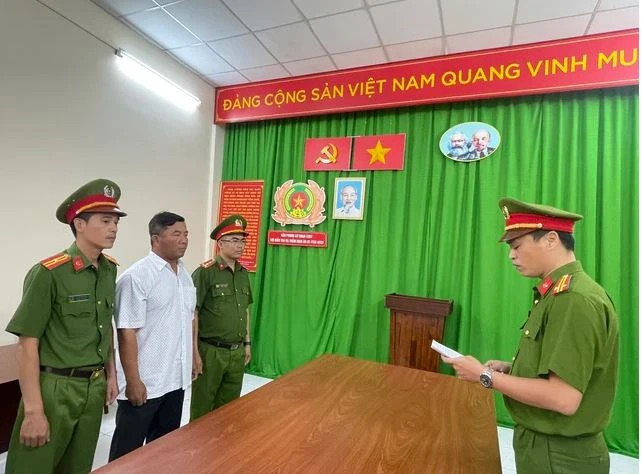 Công an đọc lệnh khởi tố Giám đốc Chi cục Đăng kiểm Long An. (Ảnh: Công an cung cấp)