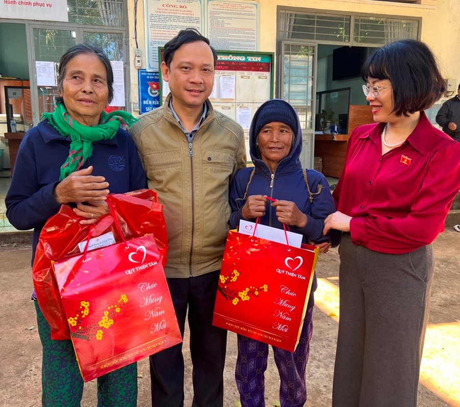 Bà Hà Thị Nhiêm (bìa trái, làng Groi, xã Kon Thụp, huyện Mang Yang) xúc động khi được nhận quà Tết. Ảnh: Đ.Y