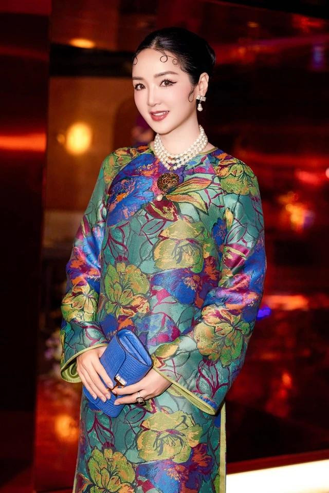 Lướt qua chiếc áo dài giống như một &quot;tổ hợp&quot; màu sắc rực rỡ tuy nhiên nhìn kỹ lại thì vẫn là các tông xanh chiếm ưu thế. Kết hợp thêm chiếc clutch màu xanh dương, người đẹp Hà Thành càng khẳng định cá tính và gu màu sắc thời trang của mình. Ảnh FACEBOOK NV