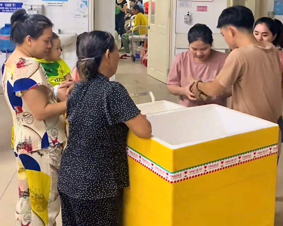 Anh Toàn thay mặt nhà hảo tâm trao phần ăn tại BV Phụ sản - Nhi Đà Nẵng. ẢNH: NVCC