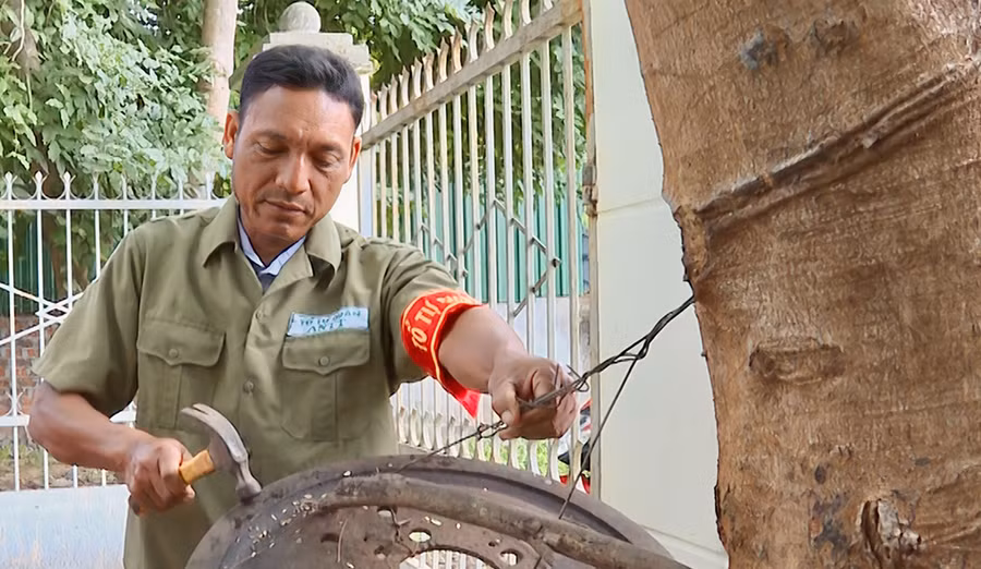 Anh Ksor Bar đánh kẻng tập hợp tổ tự quản đi tuần tra. Ảnh: Thúy Trinh