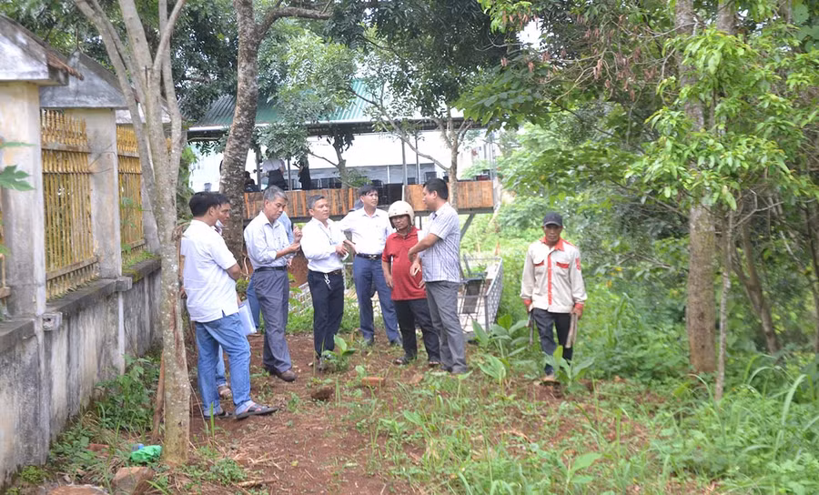 Ông Đinh Văn Đí (thứ 3 từ phải sang) lắng nghe ý kiến hòa giải của Đoàn kiểm tra thực tế bên ngoài tường rào cũ của Trường THPT Pleiku. Ảnh: Hoàng Minh