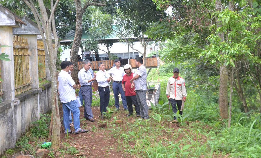 Ông Đinh Văn Đí (thứ 3 từ phải sang) lắng nghe ý kiến hòa giải của Đoàn kiểm tra thực tế bên ngoài tường rào cũ của Trường THPT Pleiku. Ảnh: Hoàng Minh