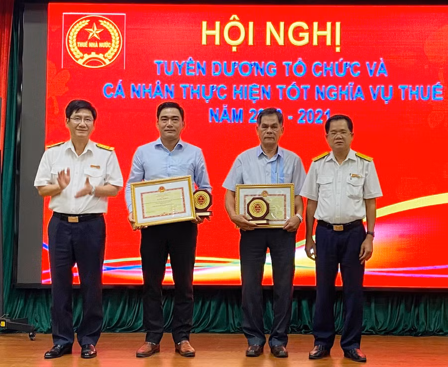 Lãnh đạo Cục Thuế tỉnh trao bằng khen của Bộ Tài chính cho 2 doanh nghiệp có thành tích tiêu biểu trong thực hiện nghĩa vụ thuế. Ảnh: Sơn Ca