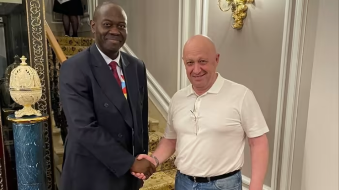 Trùm Wagner bất ngờ xuất hiện ở nơi “ít ai ngờ tới” - Ảnh 1. Ông trùm tập đoàn Wagner Yevgeny Prigozhin (phải) bắt tay với ông Freddy Mapouka, quan chức phụ trách lễ tân của Tổng thống Cộng hòa Trung Phi (CAR) Faustin-Archange Touadéra. Ảnh: Facebook/Dmitry Syty