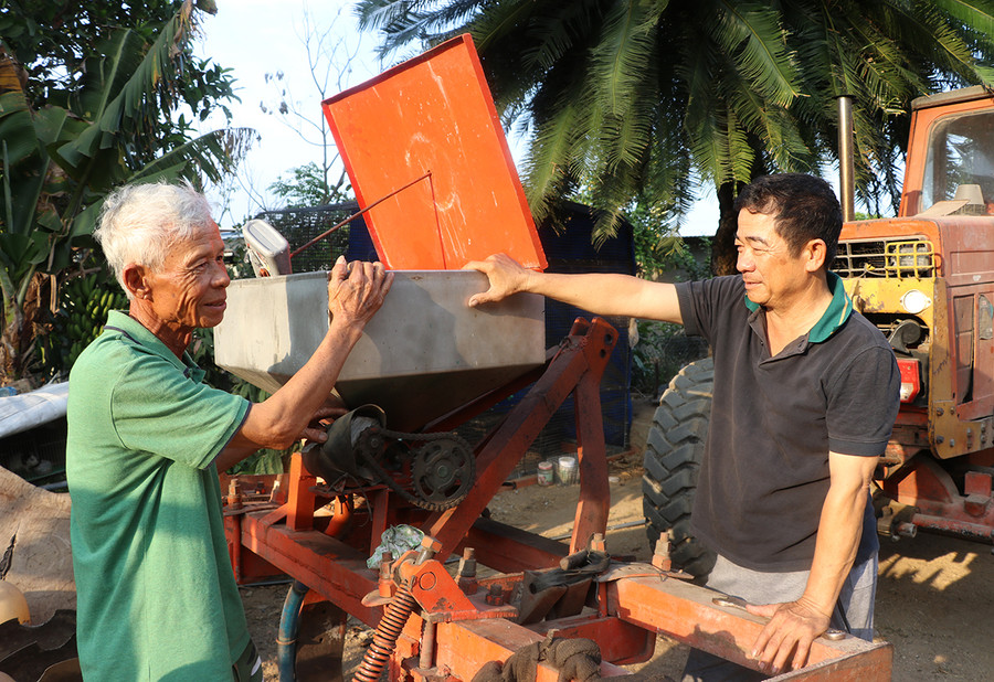 Ông Nguyễn Thái Châu (bìa trái) chia sẻ kinh nghiệm chế tạo, nâng cấp máy cày với ông Nguyễn Cho (cùng thôn Tân Định, xã Tân An, huyện Đak Pơ). Ảnh: A.P