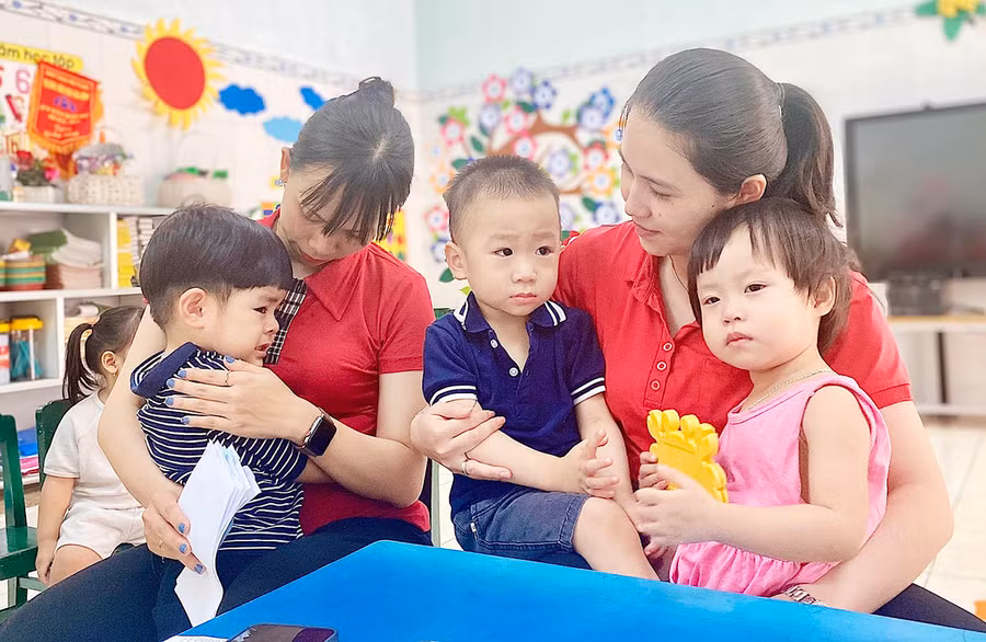 Giáo viên Trường Mầm non Hoa Hồng (phường Hội Thương, TP. Pleiku) dỗ dành các bé trong ngày đầu tổ chức hoạt động giáo dục trong hè. Ảnh: Mộc Trà