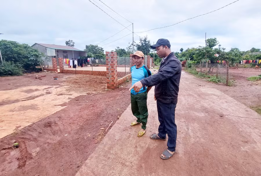 Ông Yôl (bên phải) trao đổi với người dân làng Dôr 1 về việc hiến đất làm đường. Ảnh: N.H