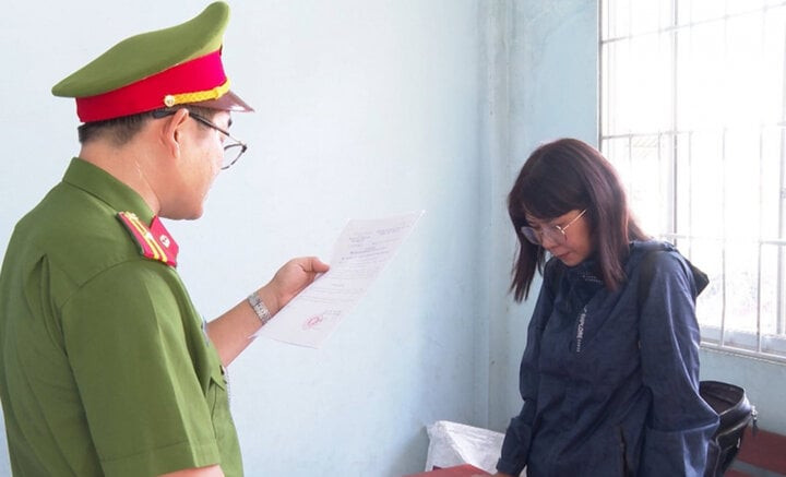 Cán bộ điều tra tống đạt quyết định khởi tố bị can Nguyễn Thị Trúc Linh. (Ảnh: Công an Vĩnh Long)