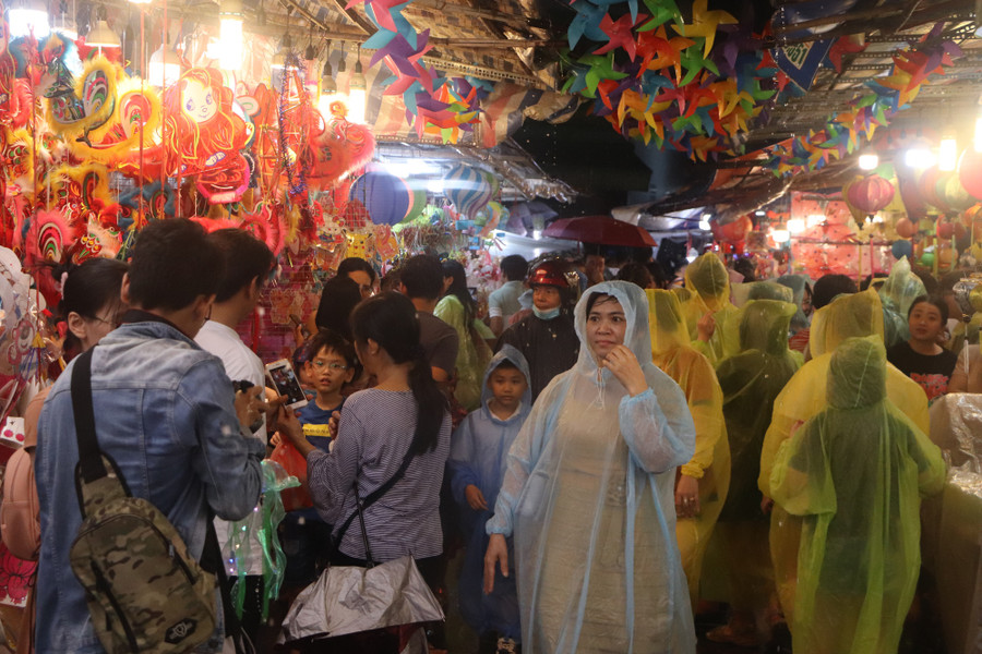 Trung thu là tết thiếu nhi, vì sao người lớn lại đi chơi nhiều? - Ảnh 7. Nhiều người mặc áo mưa tham quan, chụp ảnh tại khu phố lồng đèn vào tối 28.9. Ảnh: PHÚC KHA