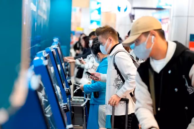 Hành khách làm thủ tục vé máy bay tại một quầy vé tự động. (Ảnh: PV/Vietnam+)