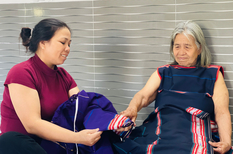Bà Nuh chỉ dạy nghề dệt cho con dâu. Ảnh: Mai Ka