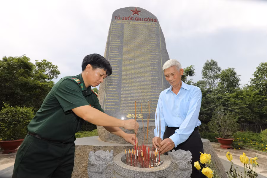 Hai thế hệ bộ đội biên phòng tại bia tưởng niệm liệt sĩ hy sinh trong chiến tranh biên giới Tây Nam, thuộc Đồn Biên phòng Phước Tân, Tây Ninh. Ảnh: DŨNG PHƯƠNG