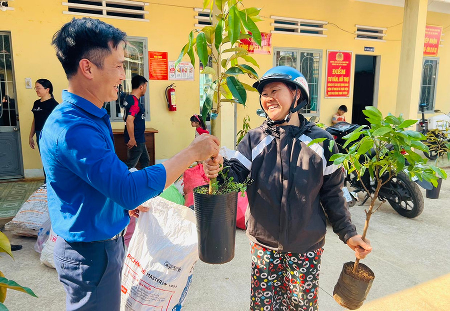 Anh Nguyễn Văn Thành (bìa trái)-Bí thư Đoàn xã Ia Nhin, huyện Chư Păh trao tặng cây ăn quả cho người dân. Ảnh: M.N