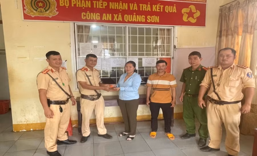 Lực lượng CSGT và Công an xã trao trả tài sản cho người dân bị đánh rơi