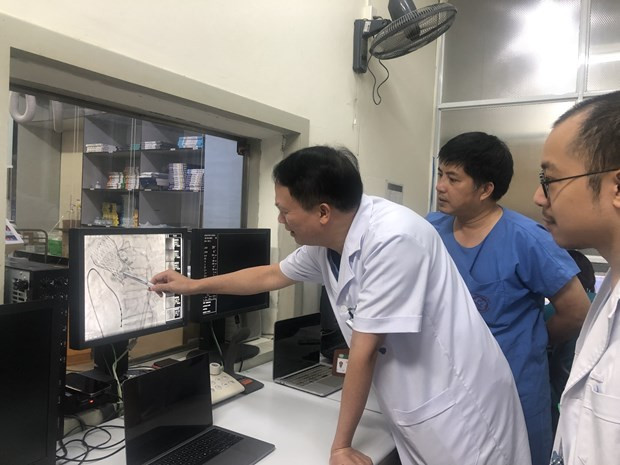 Các chuyên gia trao đổi trong quá trình thực hiện ca can thiệp. (Ảnh: PV/Vietnam+) Các chuyên gia trao đổi trong quá trình thực hiện ca can thiệp. (Ảnh: PV/Vietnam+)
