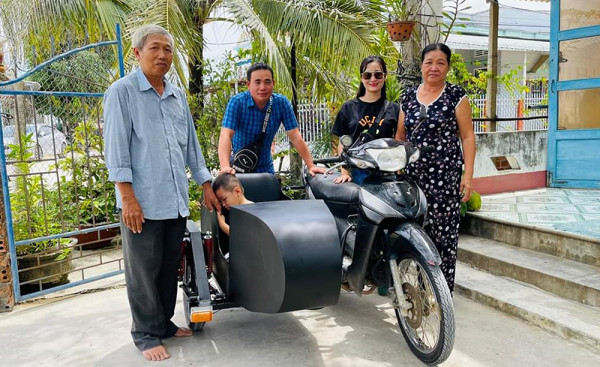 Ông Quý (người thứ hai từ trái sang) bên cạnh chiếc xe do ông độ chế cùng nhà hảo tâm hỗ trợ tiền làm xe giúp đỡ gia đình ông Cừu (ngoài cùng bên trái). Ảnh: NVCC