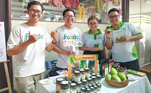 Hoàng Khang (bìa trái) giới thiệu đặc sản quê nhà qua trái xoài cát núm và sản phẩm làm từ loại xoài này. Ảnh: DUY TÂN