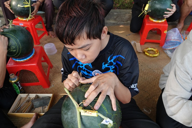 Một học sinh khiếm thính thành thục nghề có thể kiếm được tiền công khắc 50.000 - 100.000 đồng/trái dưa hấu. ẢNH DUY TÂN Một học sinh khiếm thính thành thục nghề có thể kiếm được tiền công khắc 50.000 - 100.000 đồng/trái dưa hấu. ẢNH DUY TÂN