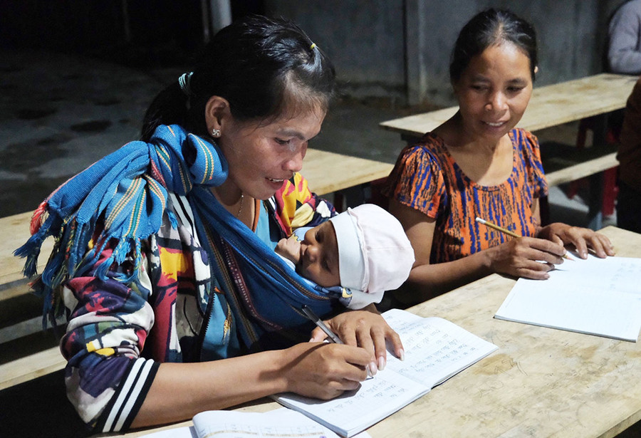 Học viên địu con nhỏ đến lớp học xóa mù chữ. Ảnh: H.N Học viên địu con nhỏ đến lớp học xóa mù chữ. Ảnh: H.N