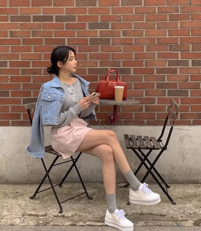 Lối lên đồ layer sở hữu nhiều điểm cộng như giúp người mặc dễ dàng "cởi ra tháo vào" trong tiết trời "ẩm ương" sáng lạnh, trưa nắng như hiện nay. Vì vậy sự kết hợp giữa áo khoác denim, áo dệt kim và chân váy kaki là hoàn toàn lý tưởng. Tuy khỏe khoắn nhưng set đồ vẫn giữ được nét tinh tế và ngọt ngào cho ngoại hình của Jinni. Ảnh: @h_you.kr