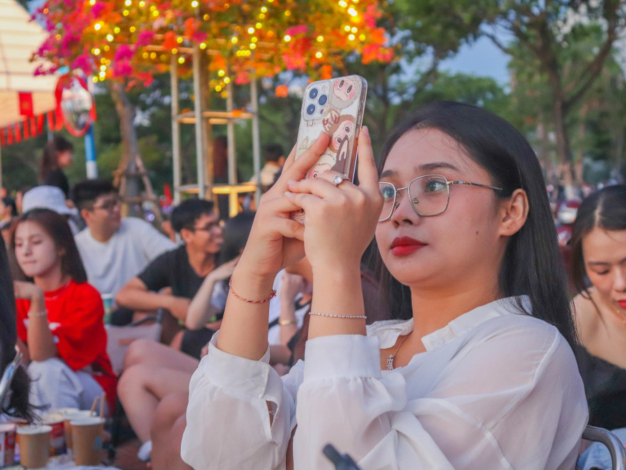 Các bạn trẻ tranh thủ chụp hình lưu giữ khoảnh khắc rạng đông bên bờ sông Hàn. ẢNH: HỮU TÚ