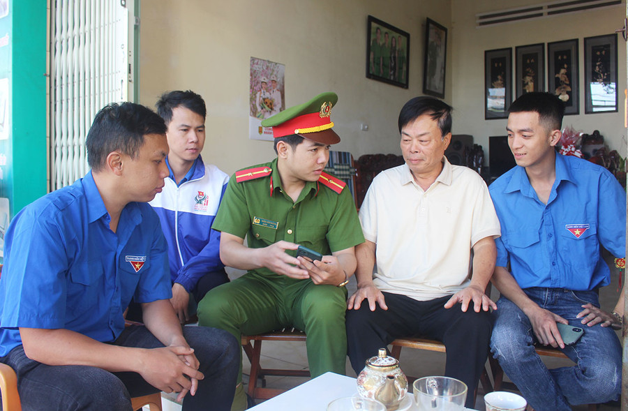 Đoàn viên, thanh niên phường Hội Thương (TP. Pleiku) hướng dẫn ông Trần Văn Hùng (thứ 2 từ phải qua) các thao tác thực hiện thủ tục hành chính trên điện thoại thông minh. Ảnh Phan Lài