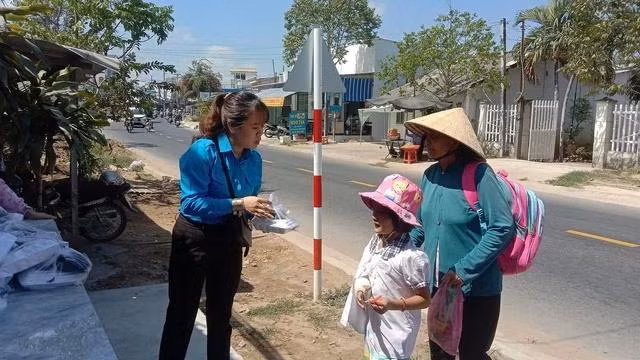 Chị Huỳnh phát cơm cho người dân có hoàn cảnh khó khăn. ẢNH: DUY TÂN