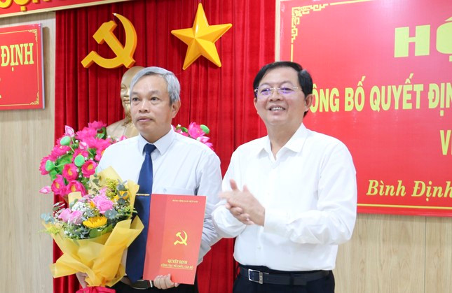 Bí thư Tỉnh ủy Bình Định Hồ Quốc Dũng trao Quyết định của Ban Bí thư, tặng hoa chúc mừng cho ông Đặng Vĩnh Sơn. Ảnh: A.T