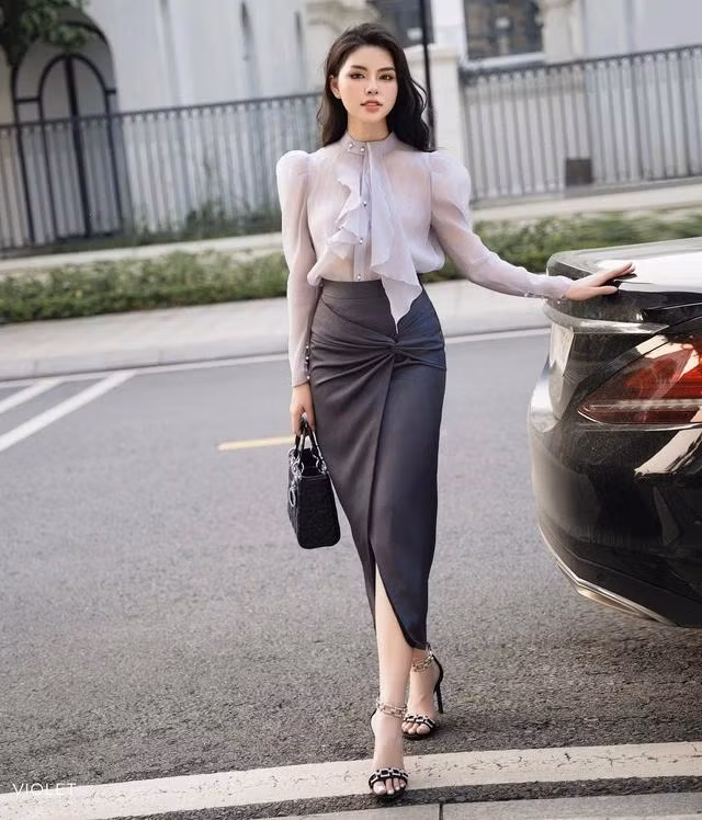 Thể hiện trọn vẹn sự nữ tính, dịu dàng cũng như phong cách thời trang thời thượng chốn công sở. Thiết kế áo blouse voan tơ cách điệu cùng chân váy màu xám trang nhã, tổng thể khiến người mặc cực kỳ thoải mái nhưng vẫn yêu kiều. Không những thanh lịch mà còn mang tính ứng dụng cao hứa hẹn một vẻ ngoài trẻ trung và tinh tế