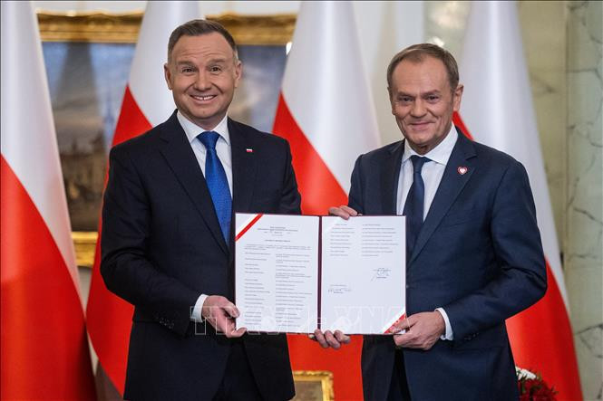 Tân Thủ tướng Ba Lan Donald Tusk (phải) tuyên thệ nhậm chức trước Tổng thống Andrzej Duda tại Vacsava, ngày 13/12/2023. Ảnh: AFP/TTXVN