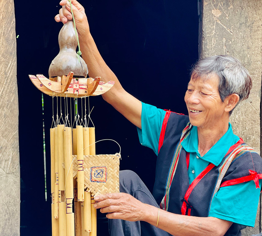 Ông Byơh bên chiếc chuông gió cổ hình cây nêu do chính tay ông chế tác. Ảnh: Trần Dung Ông Byơh bên chiếc chuông gió cổ hình cây nêu do chính tay ông chế tác. Ảnh: Trần Dung