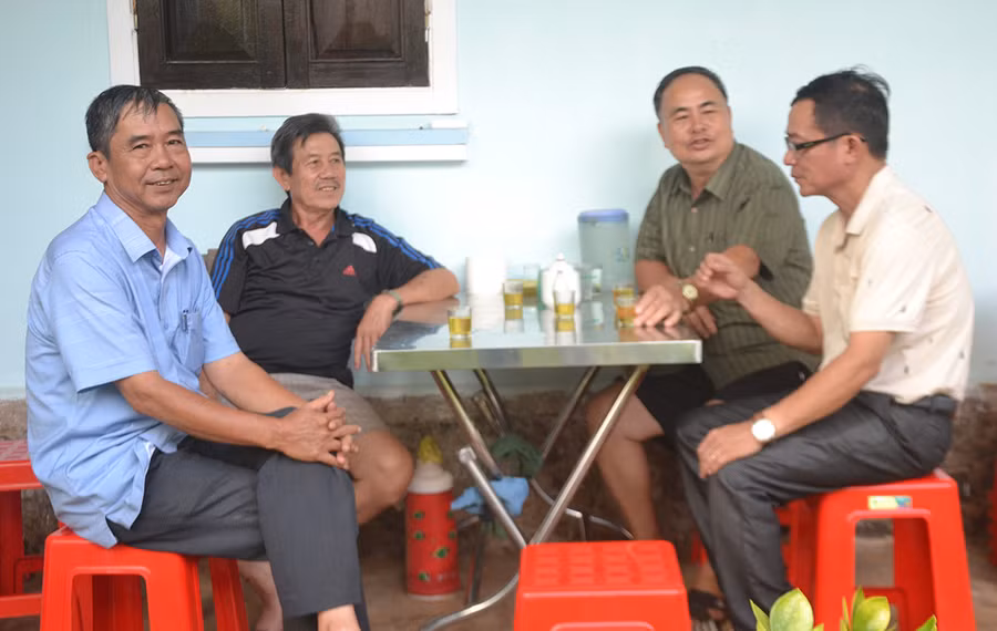 Ông Hoàng Văn Nhâm (bìa trái) trò chuyện với người dân về việc nâng cấp vỉa hè, lề đường tổ dân phố 4. Ảnh: H.C