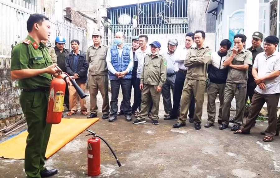 Cán bộ Công an TP. Pleiku hướng dẫn người dân sử dụng bình chữa cháy. Ảnh: R'Ô HOK
