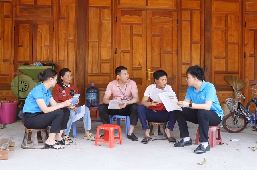 Cán bộ BHXH huyện Phong Thổ (Lai Châu) tuyên truyền đến người dân về những lợi ích, quyền lợi khi tham gia đóng bảo hiểm xã hội tự nguyện tại bản Lả Nhì Thàng. (Ảnh: Quý Trung/TTXVN)