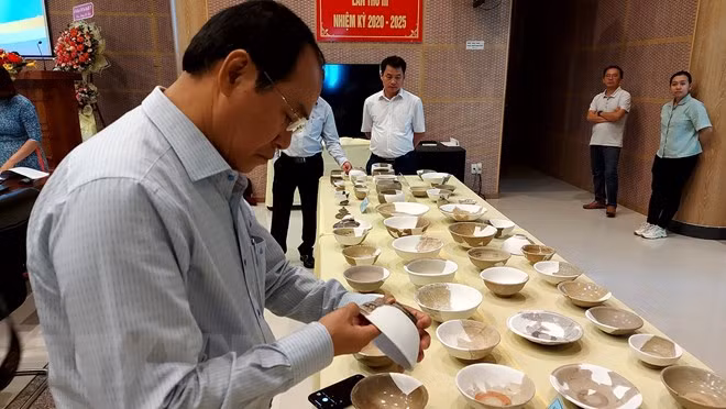 Các đại biểu tham quan nhóm đồ sứ, đồ bán sứ và đồ sành được khai quật tại di tích Vòng Thành Đá Trắng. (Ảnh: Huỳnh Sơn/TTXVN)