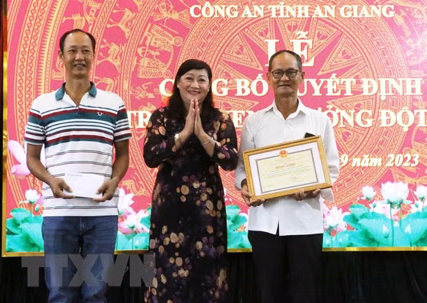 Thừa ủy quyền của Chủ tịch UBND thành phố Cần Thơ, Trưởng Ban Thi đua Khen thưởng thành phố Cần Thơ Hồ Lâm Bạch Vân trao Bằng khen của UBND thành phố Cần Thơ cho ông Bùi Ngọc Thọ và anh Bùi Hữu Thành vì hành động, nghĩa cử cao đẹp cứu sống bé trai bị ném từ trên cầu xuống sông. (Ảnh: Công Mạo/TTXVN)