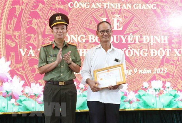 Đại tá Lê Phú Thạnh, Phó Giám đốc Công an tỉnh An Giang tặng Giấy khen của Giám đốc Công an tỉnh An Giang cho ông Bùi Ngọc Thọ. (Ảnh: Công Mạo/TTXVN)