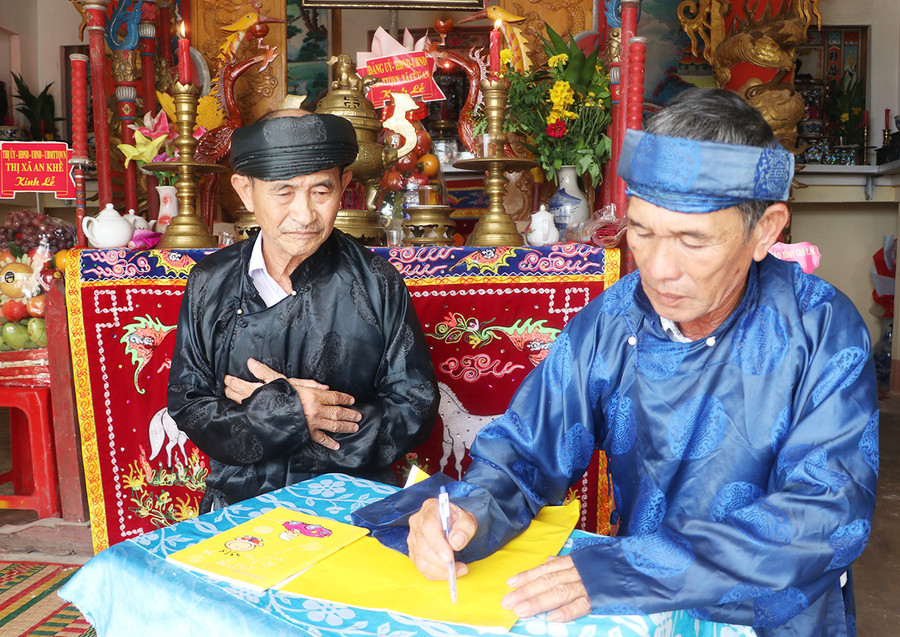 Thành viên Ban Nghi lễ đình Cửu An (xã Cửu An, thị xã An Khê) viết văn tế trước khi tiến hành cúng tế. Ảnh: N.M