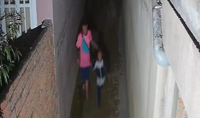 Đen đưa cháu A chạy vào hẻm nhỏ trên đường Khe Sanh. Ảnh CẮT TỪ CLIP