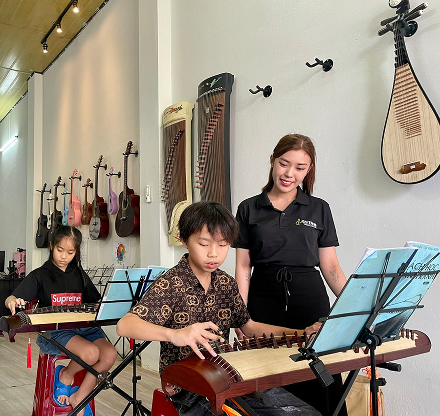 Chị Hồ Thị Như Quỳnh hướng dẫn học viên tập đánh đàn tranh. Ảnh: L.N